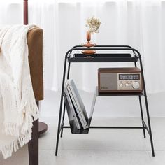 a radio sits on top of a shelf next to a bed with a white blanket