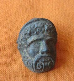 a stone head is sitting on an orange cloth