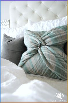 a bed with two pillows on top of it and a white headboard behind it