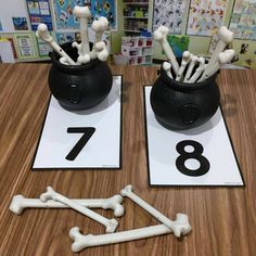 two black vases filled with bones and bones on top of a wooden table next to each other