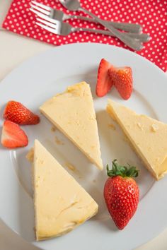 four slices of cheesecake with strawberries on a plate