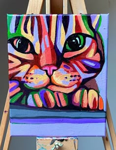 a painting of a colorful cat on an easel