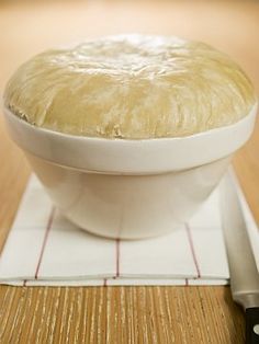 a white bowl filled with food sitting on top of a cutting board