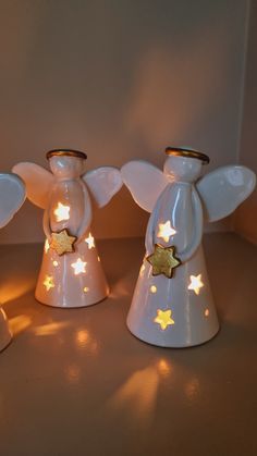 three white angel figurines with gold stars on them