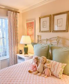 two stuffed animals sitting on top of a bed in a bedroom next to a window