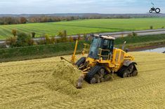 a yellow tractor is driving through the field