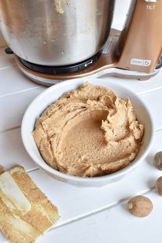 a bowl filled with peanut butter next to an electric mixer