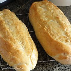 two loaves of bread cooling on a rack next to an instant pressure cooker