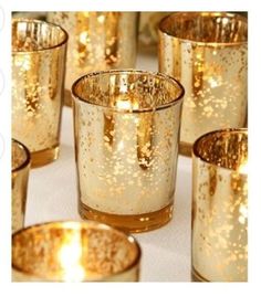 gold colored candles are lined up on a table