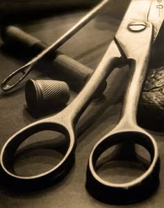 an old pair of scissors sitting on top of a table next to some other tools