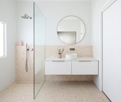 a bathroom with a sink, mirror and shower stall in the corner next to it