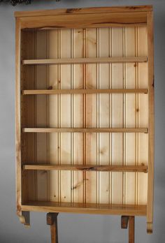 a wooden bookcase with two legs and three shelves