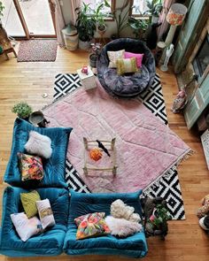 an overhead view of a living room with blue couches and pillows on the floor