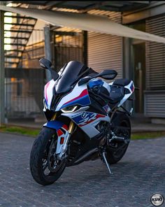 a white and blue motorcycle parked in front of a building