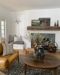 a living room filled with furniture and a fire place in front of a mantle on the wall