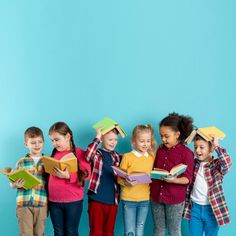 a group of children standing next to each other with books on their heads and holding books in their hands