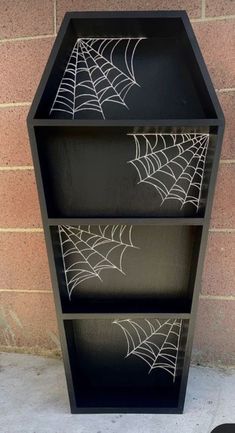 a black shelf with spider webs painted on it