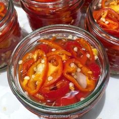 several jars filled with different types of food on top of a white tableclothed surface