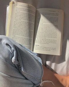 an open book sitting on top of a bed