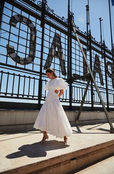 a woman in a white dress is standing on some steps near a sign that says chicago