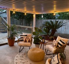 a covered patio with seating and potted plants