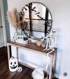 a wooden table topped with a mirror next to a halloween decoration on top of a hard wood floor