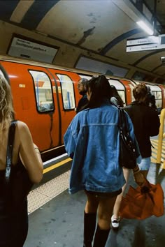 several people are walking towards a subway train