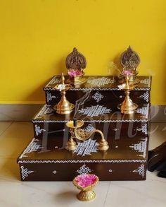 an assortment of decorative items on display in front of a yellow wall