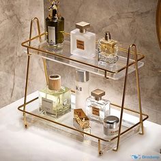 three tiered glass shelf with bottles and perfumes on it