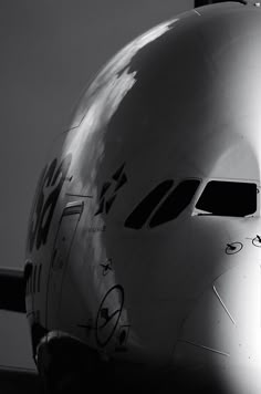 the nose of an airplane with writing on it's side and windows, in black and white