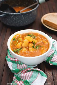 a white bowl filled with soup on top of a wooden table