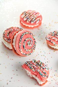 some pink frosted pastries with sprinkles on them