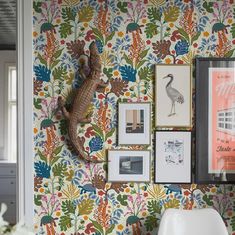 the wallpaper is colorful and has an animal on it's head, as well as various framed pictures