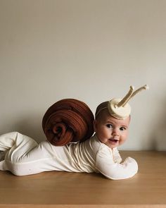 a baby laying on its back with a hat on top of it's head