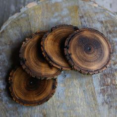 three slices of wood sitting on top of a piece of wood with holes in it