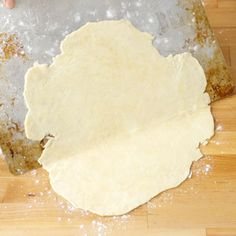 a person is kneading dough on a wooden table