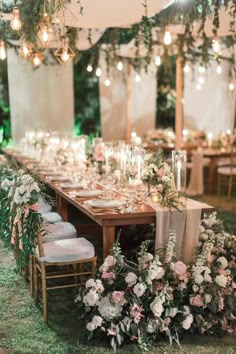 a long table with flowers and greenery is set up for an outdoor wedding reception