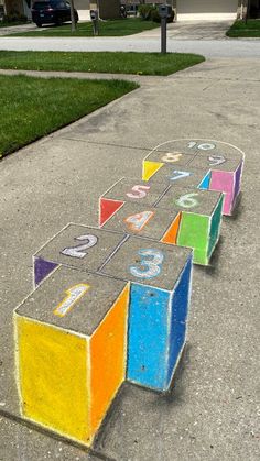 the sidewalk has been painted with chalk and numbers on it, as if they were cubes