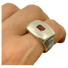 Bold, modern, sculptural, chunky garnet and sterling silver signet statement ring by Lebanese designer Rosa Maria. Marks: Rosa Maria, 925 for Sterling Silver Size: 8.5 Weight: 29.8 grams Condition: Very Good, light surface wear, nice patina Ring Face: 22mm by 15mm Garnet: 6mm by 4mm, emerald cut, lively burgundy Provenance: from the collection of a noted NYC psychiatrist and collector of unusual, often one-of-a-kind jewels. This sophisticated, modern Rosa Maria signet ring centers an emerald cut Chunky Statement Ring, Chunky Silver Rings, European Jewelry, Unusual Rings, Silver Horse, Modernist Jewelry, Gold Ring Designs, Silver Signet Ring, Gold Signet Ring