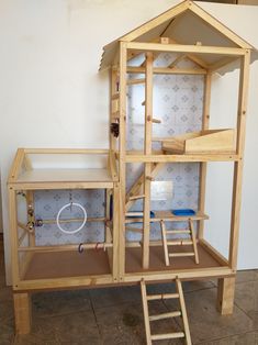 a doll house made out of plywood and wood with ladders on the floor