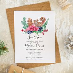 an image of a wedding card on top of a table with pine cones and presents