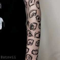 a person with tattoos on their arms has an eyeball tattoo on his left arm