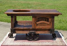 an old wooden cart with a sink on it's wheels and some grass in the background