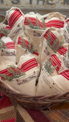 a basket filled with lots of red and white cloth covered christmas stockings sitting on top of a table