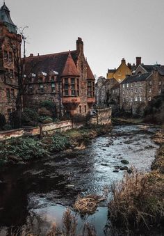 a river running through a small town next to tall brick buildings on either side of it