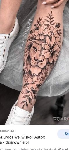 a woman's leg with flowers and a lion on it