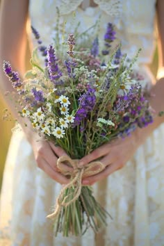 a woman holding a bouquet of flowers in her hands