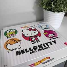 the hello kitty and friends box is next to a potted plant on a table