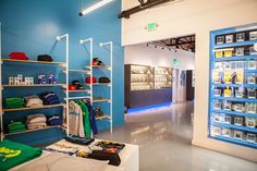 the inside of a clothing store with blue walls and shelves full of items on display