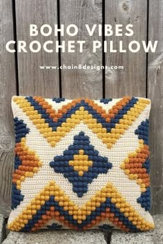 a crocheted pillow sitting on top of a wooden bench